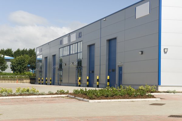 Exterior of a small warehouse with bay doors.