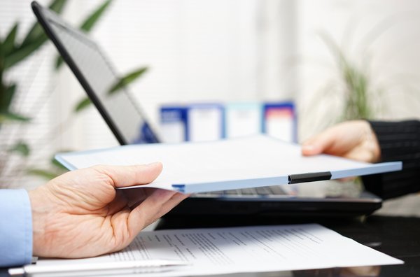 Person handing over a document.